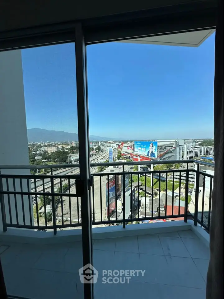 Stunning cityscape view from a high-rise balcony with clear blue skies.