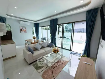 Modern living room with pool view, stylish furniture, and natural light