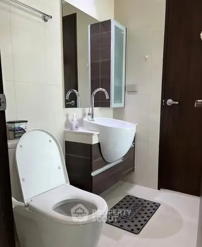 Modern bathroom with sleek fixtures and elegant design, featuring a stylish vanity and contemporary toilet.