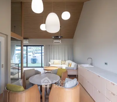 Modern open-plan living room with stylish furniture and large windows offering natural light.