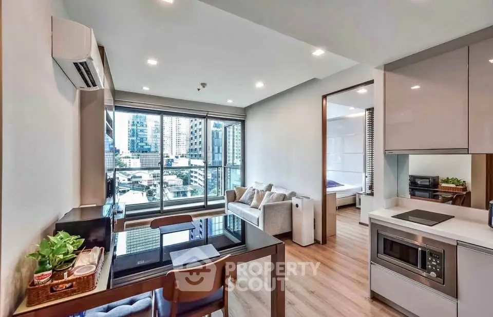 Modern open-plan living room with city view, sleek kitchen, and cozy bedroom in urban apartment.