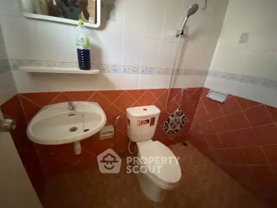 Cozy bathroom with vibrant tile design and essential fixtures, perfect for a compact living space.