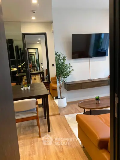 Modern living room with stylish furniture and wall-mounted TV, featuring a sleek wooden floor and elegant decor.