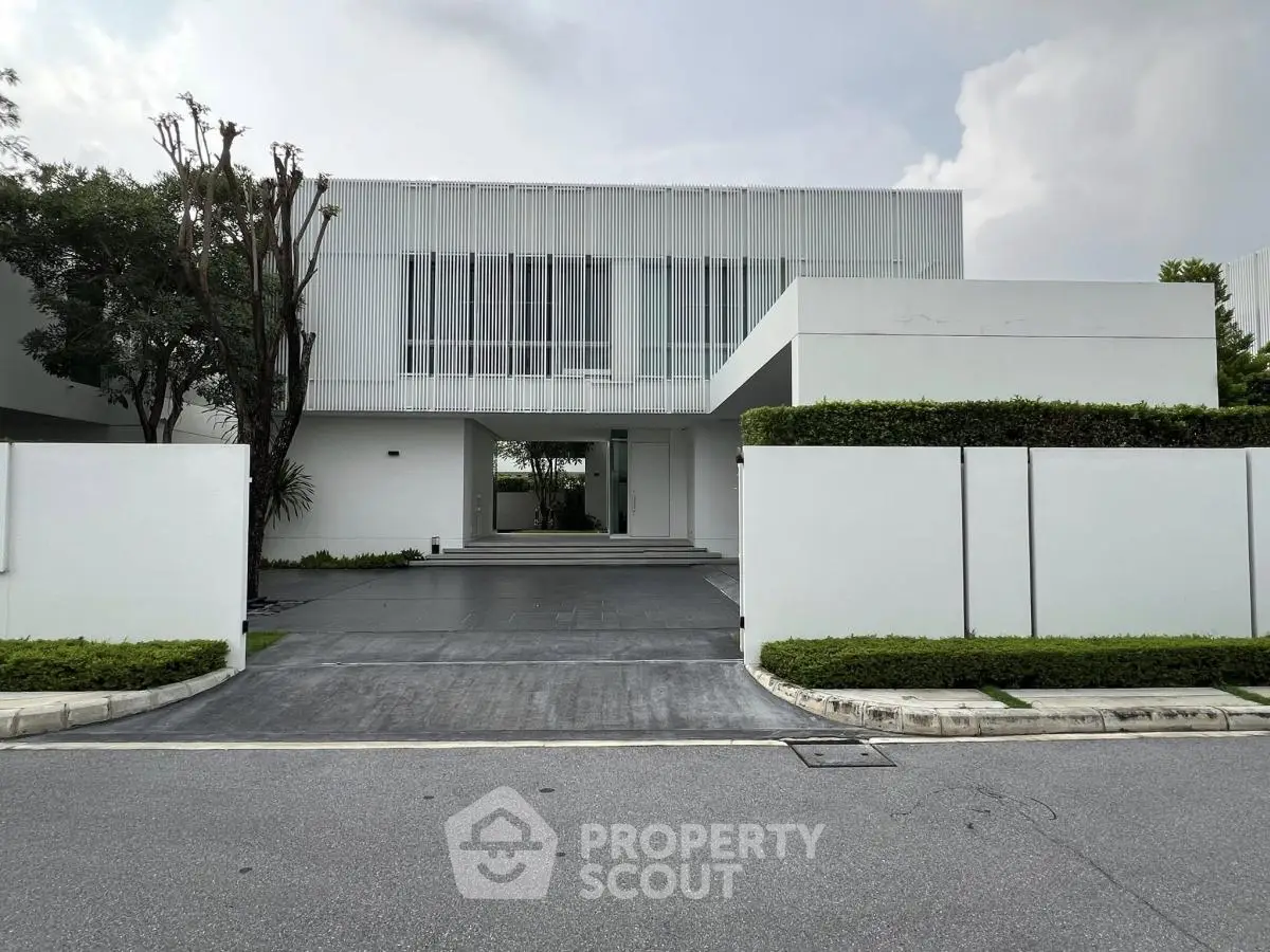 Modern minimalist white house with sleek facade and lush greenery