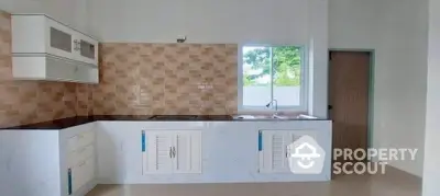 Modern kitchen with stylish cabinets and tiled backsplash in a bright, airy space.