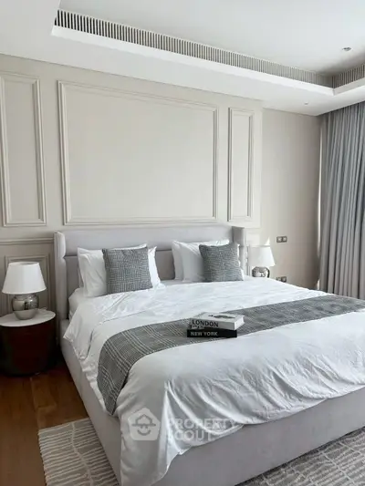 Luxurious bedroom with elegant decor and plush bedding in modern apartment.