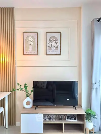 Modern living room with stylish decor and flat-screen TV on wooden stand, perfect for cozy relaxation.