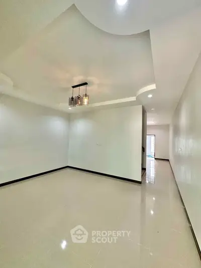Spacious modern living room with elegant ceiling design and ample natural light.