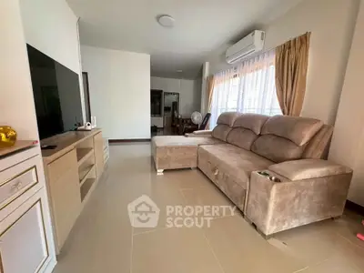 Spacious living room with plush sofa and modern entertainment unit, perfect for relaxation and entertainment.