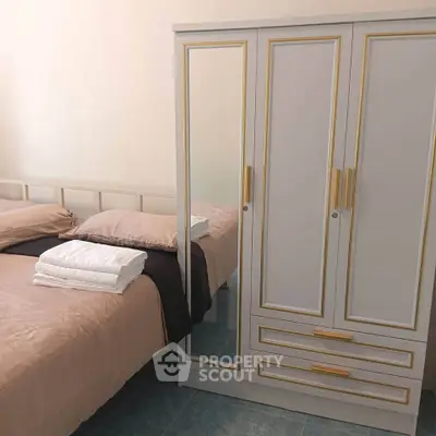 Cozy bedroom with elegant wardrobe and neatly arranged bedding, perfect for a comfortable living space.