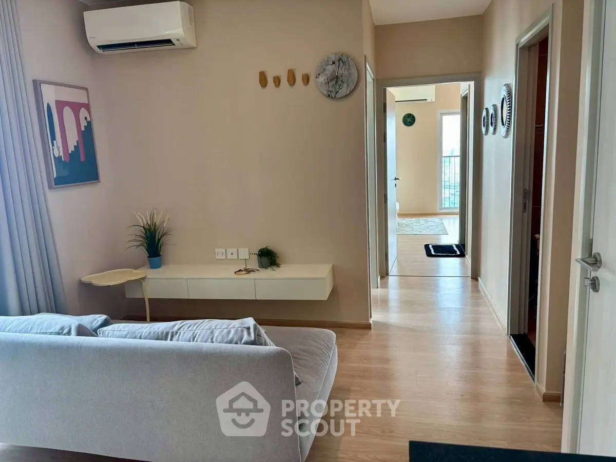 Modern living room with sleek design and air conditioning, featuring a cozy sofa and stylish decor.