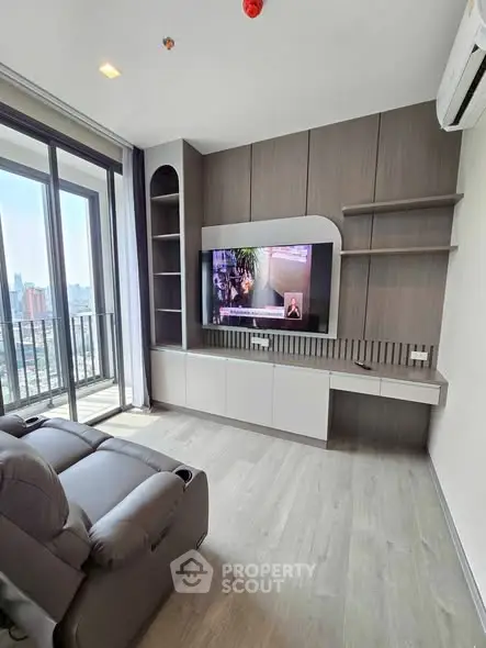 Modern living room with sleek entertainment unit and city view balcony.