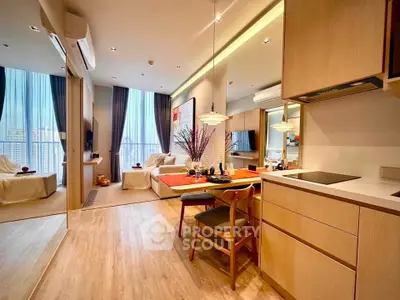 Modern open-plan living room and kitchen with stylish decor and large windows.