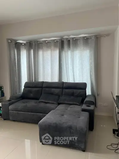 Modern living room with plush gray sectional sofa and elegant curtains