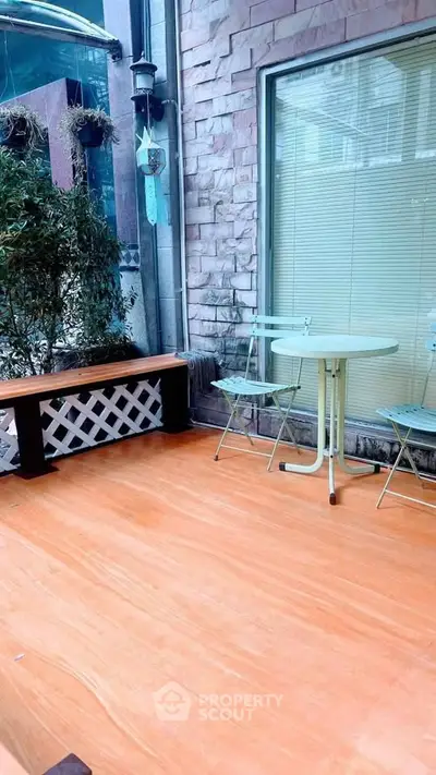 Charming balcony with seating area and greenery, perfect for relaxation.