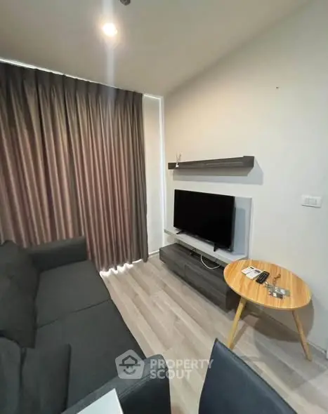 Modern living room with sleek furniture and large TV, perfect for relaxation and entertainment.