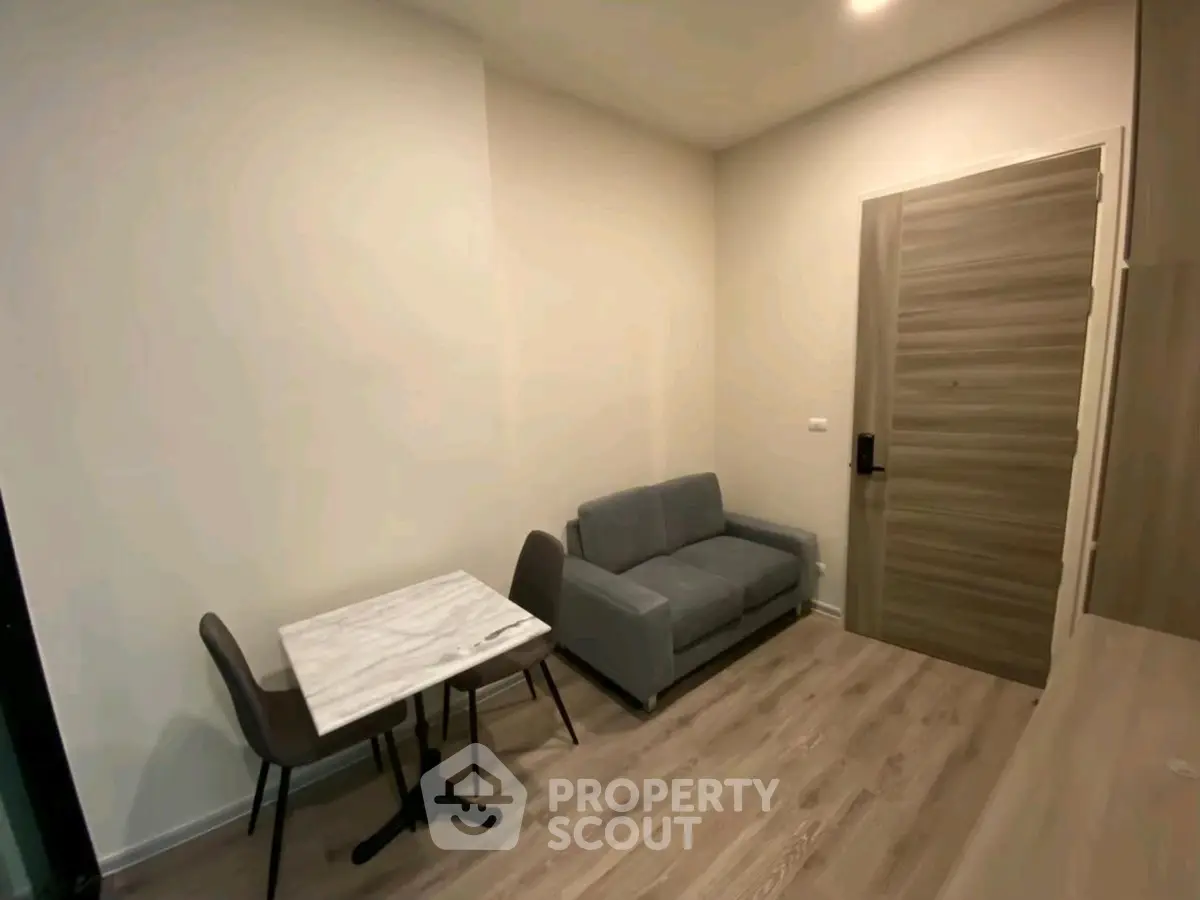 Cozy modern living room with compact sofa and dining table, perfect for urban living.