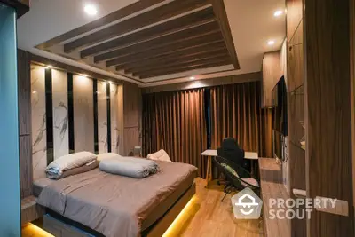 Modern bedroom with stylish wood paneling, ambient lighting, and a cozy workspace, perfect for urban living.