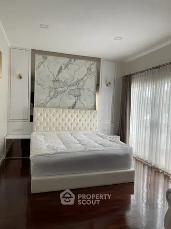 Luxurious bedroom with elegant marble accent wall and plush bed