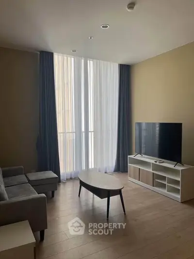 Modern living room with sleek furniture and large window, perfect for urban living.