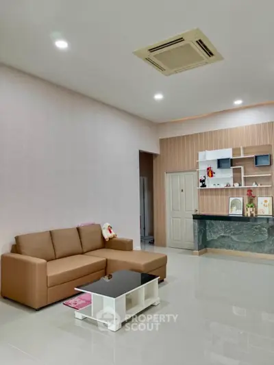 Spacious modern living room with stylish sofa and open kitchen layout