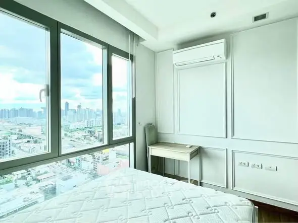 Bright bedroom with city view and modern air conditioning unit.