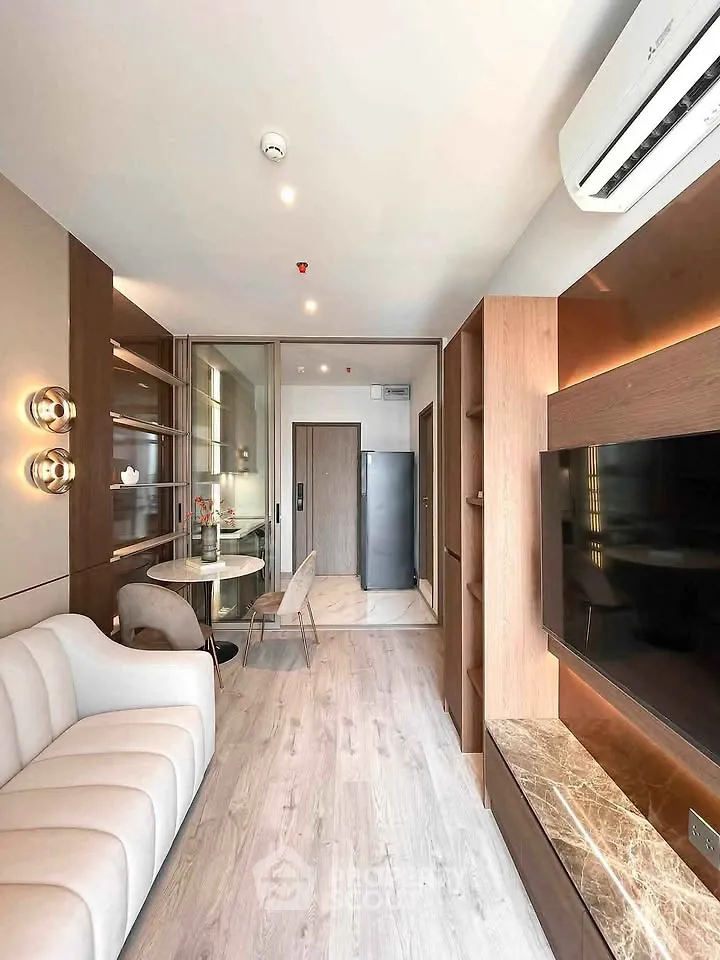 Modern living room with elegant decor and open layout, featuring a cozy sofa and sleek TV unit.