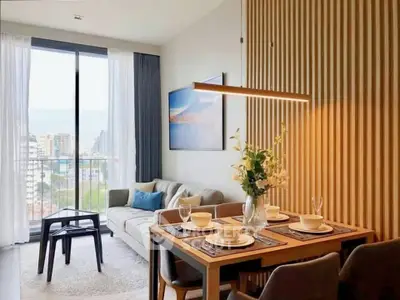 Modern living room with dining area and city view, featuring elegant decor and natural light.
