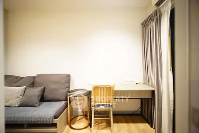 Cozy living room with modern sofa and study desk, perfect for relaxation and work-from-home setup.