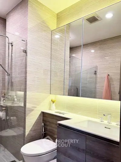 Modern bathroom with sleek design, glass shower, and elegant lighting