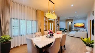 Luxurious open-plan living and dining area with elegant chandelier and modern decor