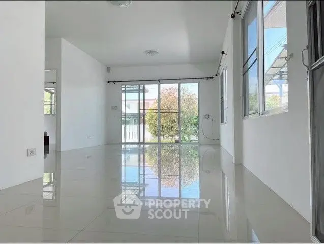 Spacious empty living room with large windows and glossy tiled floors