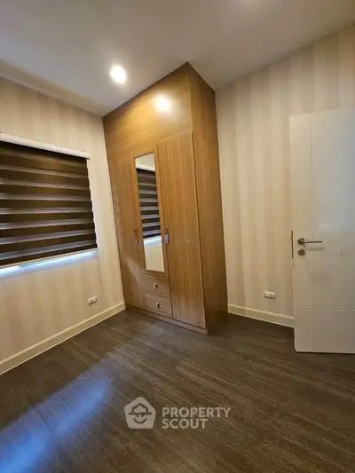 Spacious bedroom with modern wardrobe and stylish blinds, perfect for comfortable living.