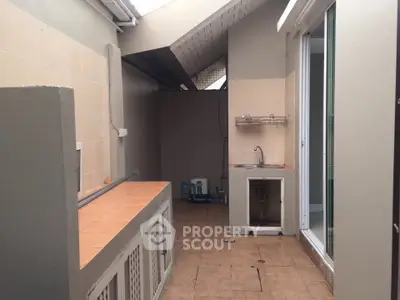 Spacious utility area with sink and storage, ideal for laundry or extra kitchen space.