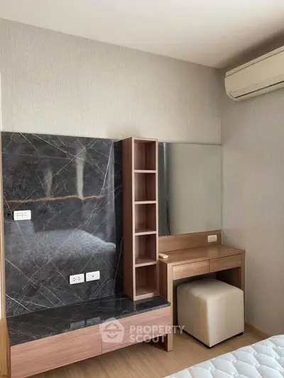 Modern bedroom with stylish marble accent wall and built-in vanity desk