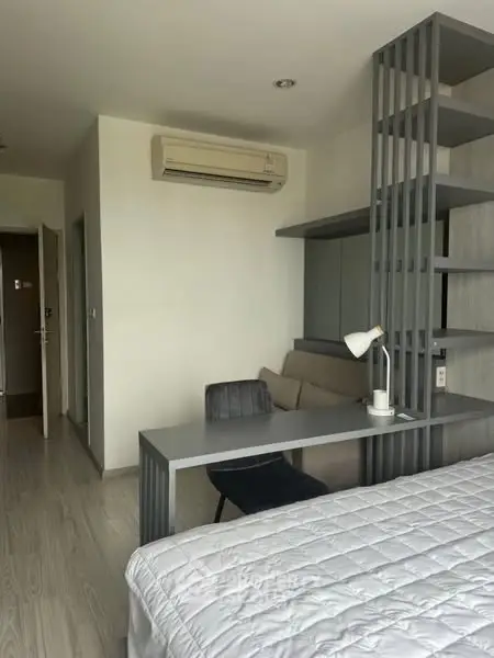 Modern bedroom with sleek desk and air conditioning, ideal for comfortable living.