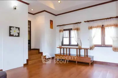 Spacious living room with wooden flooring and elegant decor in a modern home.