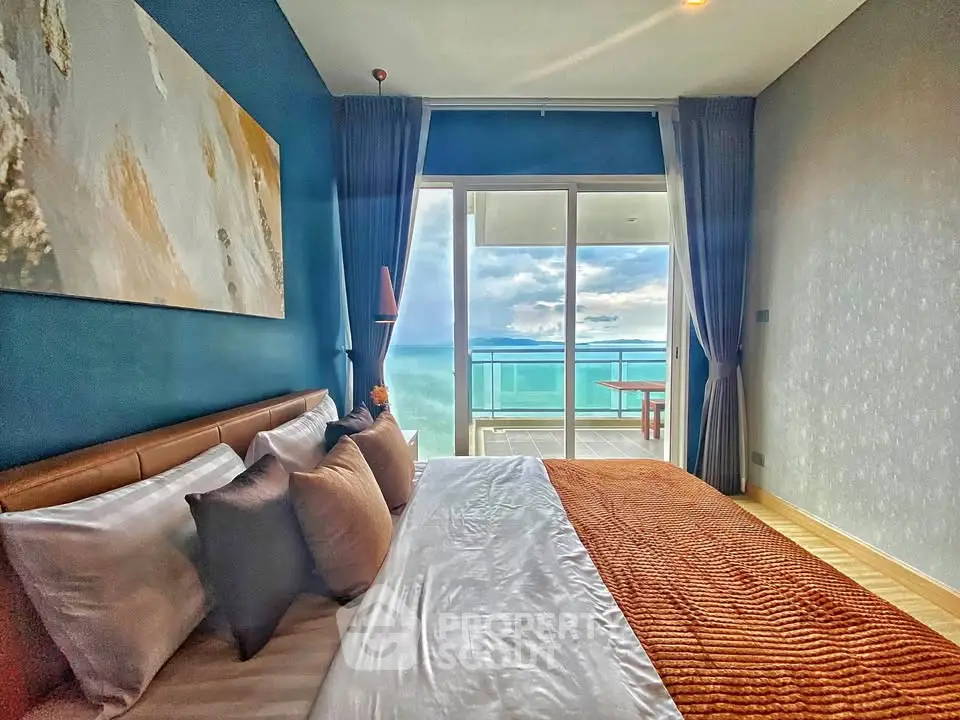 Luxurious bedroom with ocean view and balcony access, featuring elegant decor and plush bedding.
