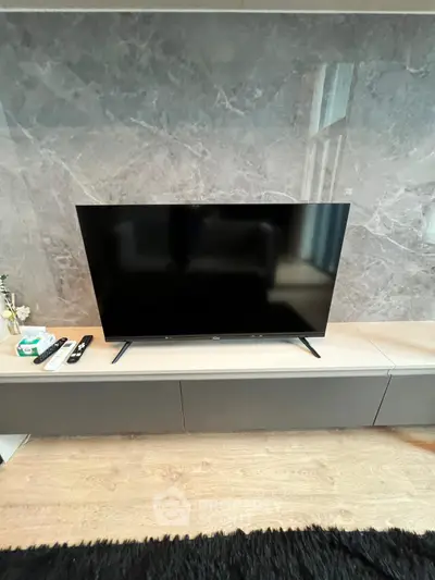 Modern living room with sleek TV setup and elegant marble wall