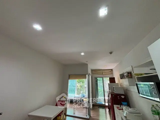 Spacious living room with modern decor and large windows opening to a balcony, perfect for natural light.