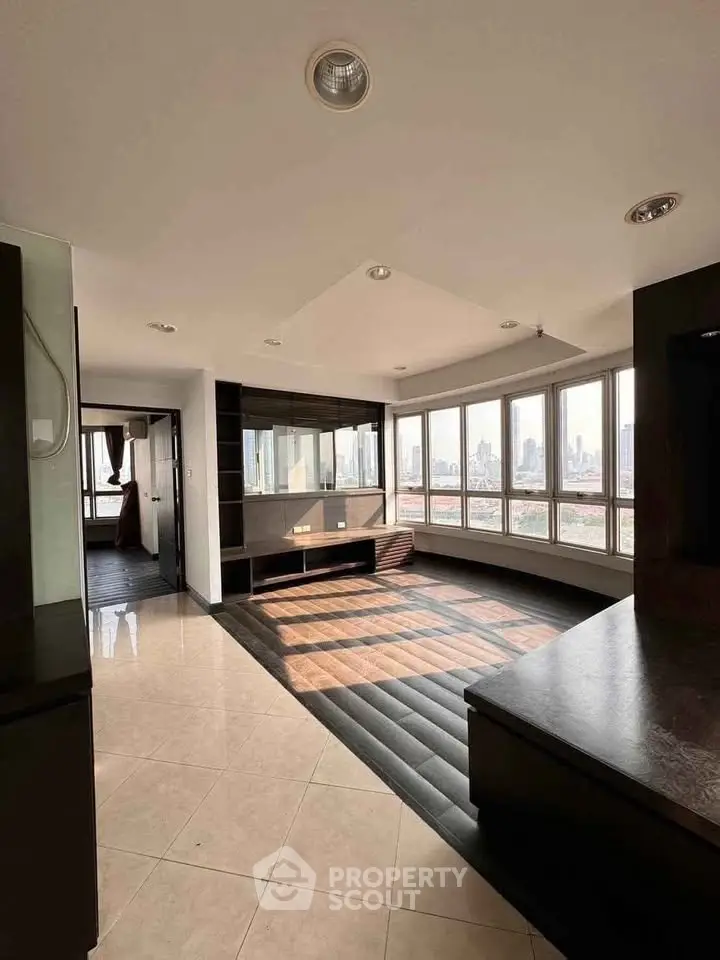 Spacious modern living room with panoramic city views and sleek design elements.