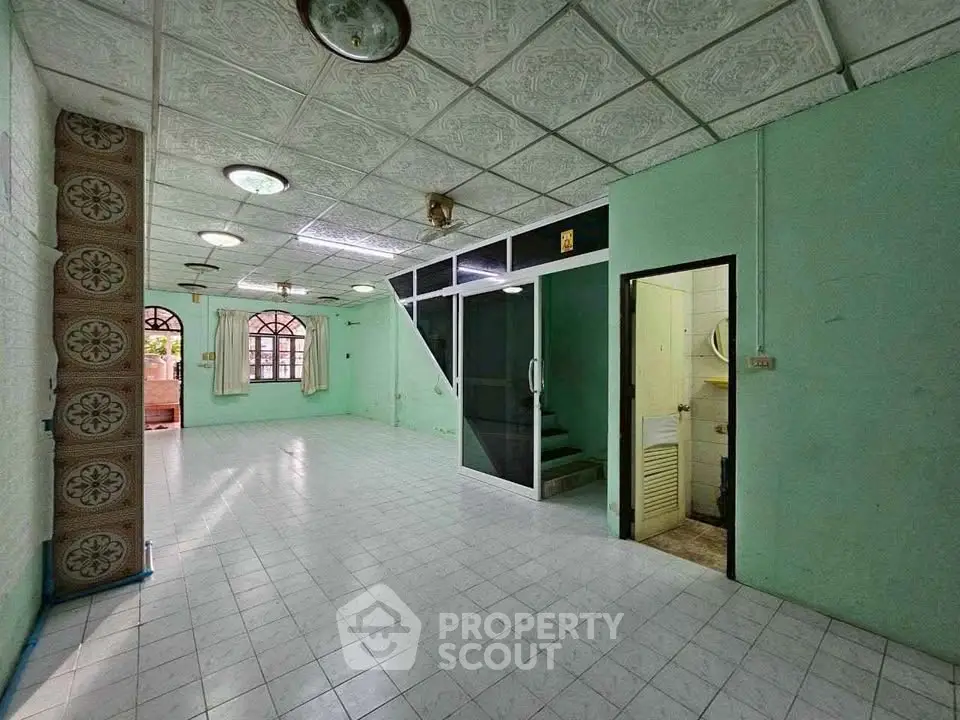 Spacious open-plan living area with tiled floors and unique ceiling design.