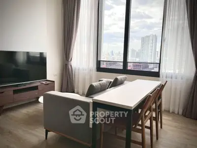 Modern living room with city view, stylish furniture, and large windows.