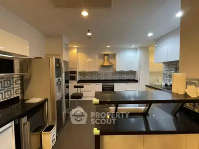 Modern kitchen with sleek black countertops and stainless steel appliances in a stylish open layout.