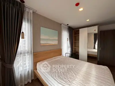 Modern bedroom with stylish decor and ample natural light, featuring a cozy bed and elegant curtains.