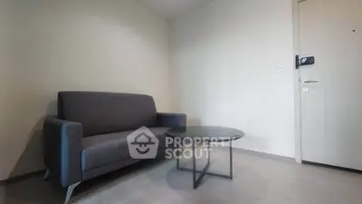 Modern minimalist living room with sleek gray sofa and round coffee table, perfect for cozy relaxation.