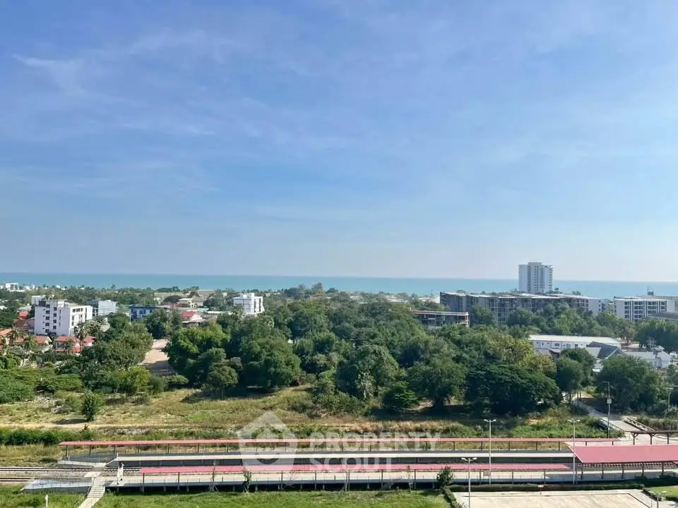 Stunning panoramic view of coastal cityscape with lush greenery and ocean horizon.