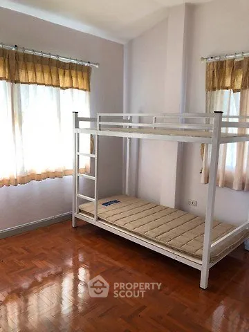 Cozy bedroom with bunk bed and wooden flooring, perfect for small spaces.