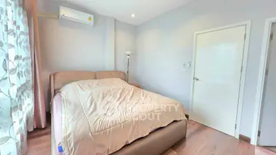 Cozy bedroom with modern decor and natural light in a stylish apartment.