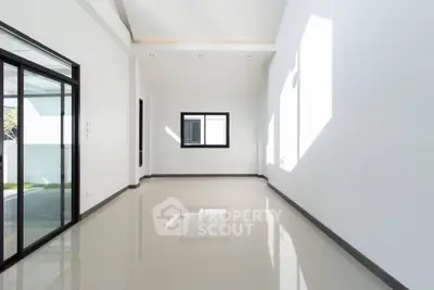 Spacious modern living room with large windows and glossy floors